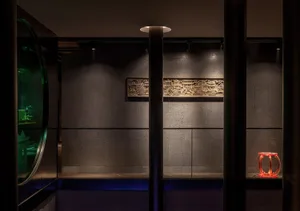A modern hotel suite with concrete walls and ambient lighting.