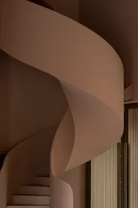 Modern interior with flowing, curved concrete staircase