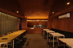 A modern cafe interior with concrete walls and wooden accents.