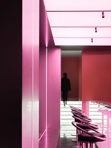 A sleek, minimalist restaurant interior featuring metallic pink materials.