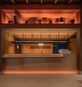 A wooden cafe bar interior with bottles hanging above the countertop.