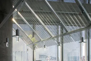 A modern, industrial office space featuring a grid ceiling made of metal.