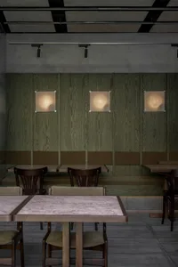 Modern industrial-style restaurant interior with wooden paneling and seating.
