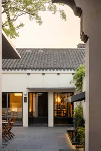 Modern minimalist restaurant interior with concrete walls and glass features.