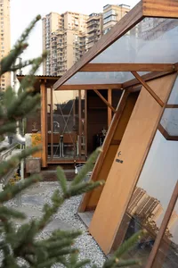 Modern modular house with wood and glass construction on a rooftop.