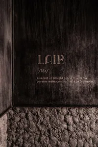 A close-up view of a dark wall interior with wood texture, featuring the word 'Lair' engraved on it.