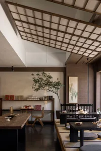 A photograph showcasing a modern restaurant interior with minimalist design, featuring wooden furniture, a tree, and contempo