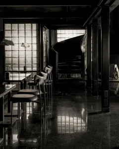 A modern minimalist bar with concrete seating and floor.