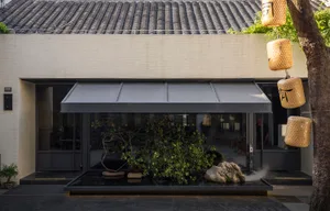 現代簡約住宅室內，搭配簡約家具擺設、白牆與黑色水景裝置