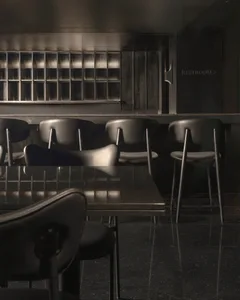 Industrial-themed restaurant interior with metallic counter, leather seating, and glass partitions.