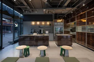 Interior view of a dark industrial-style coffee shop with modern seating and counter.