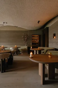 A photograph of a minimalist restaurant with wooden furniture and a cozy atmosphere.