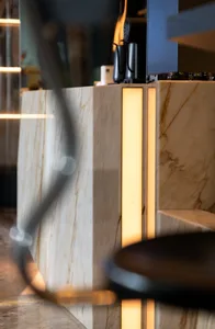 Modern bathroom with marble tiles, illuminated sink, and sleek fixtures.