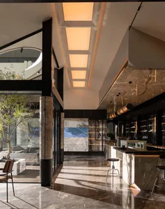 A modern restaurant bar interior featuring marble materials and a sleek design.