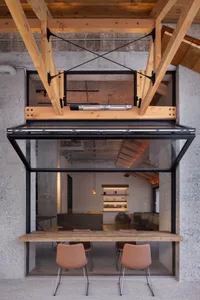 Industrial-style cafe featuring concrete walls, glass windows, and wooden furniture.