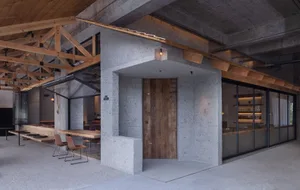 A modern restaurant with exposed concrete walls and wooden accents.