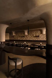 A photograph of an industrial-style restaurant interior with brick and stone walls.