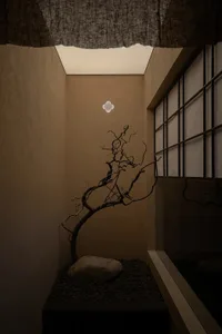 A minimalist corridor featuring concrete walls, stone flooring, and gravel accents.