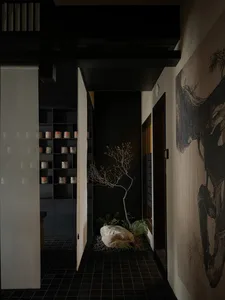 現代玄關採用深色調瓷磚，搭配小型石庭與光禿樹木，以及一面繪有大型樹木壁畫的牆面