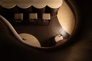 A curved wooden floor with chairs and tables.