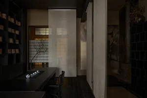 A traditional tea room featuring black tiles, wood accents, and fabric curtains.