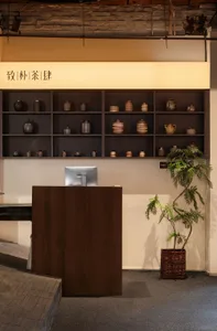 Retail console with various ceramic jars, brick walls, wooden shelves, and a metal desk.