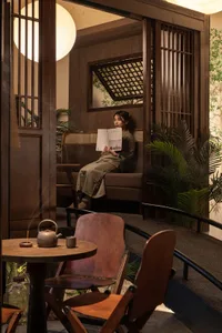 A cozy café interior with a woman reading a book.