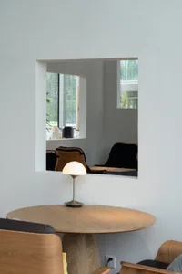 A cozy cafe interior featuring a wooden table, modern lighting, and a minimalist design aesthetic.