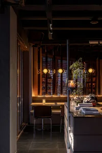 Industrial-themed restaurant interior featuring metal, wood, glass, and concrete materials.