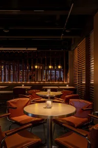 An industrial-style restaurant interior with wooden furniture and warm lighting.