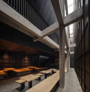 Interior view of a modern cafe with concrete walls and tables, minimalist design.