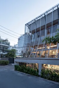 Modern industrial building facade with concrete walls, glass windows, and metal framing.