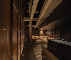 A modern restaurant interior featuring concrete and wooden elements.