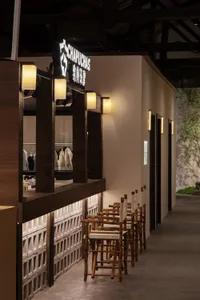 A cozy, industrial-themed bar with wooden stools and a wooden counter.