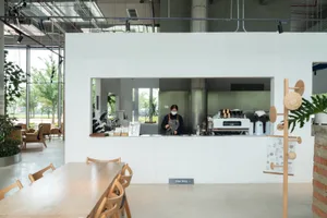 A minimalist coffee shop counter with metal elements and a concrete base.