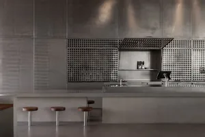 Modern kitchen bar featuring metallic and concrete materials with industrial design elements