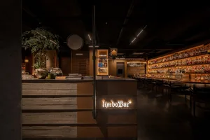 A modern restaurant bar with wooden accents and a warm, inviting atmosphere.