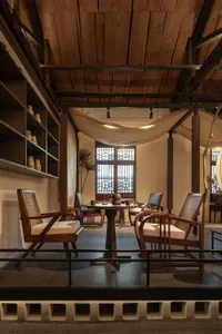 A cozy traditional-style living room with wooden furniture and a rustic ceiling.