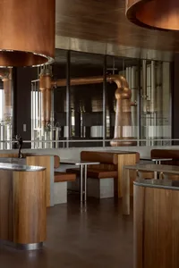 A modern restaurant bar featuring copper and wooden materials.