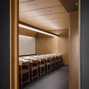 A minimalist restaurant interior featuring wooden tables and chairs with white tablecloths and plates.