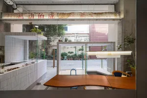 A minimalist industrial coffee shop interior with concrete walls and plants.