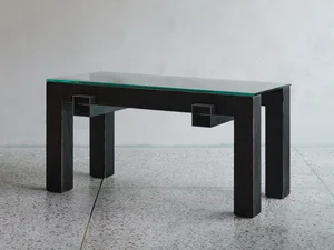 A minimalist coffee table with a glass top and metal legs