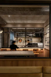 Modern industrial cafe interior with concrete tiles and wooden seating.