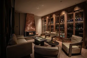 Modern living room with warm, cozy interior design featuring wood, leather, and brick materials.