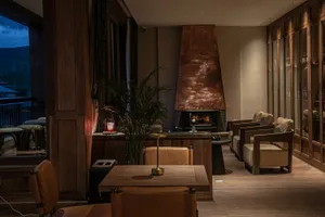 A modern restaurant and bar interior with wooden furniture, glass decor, and a warm, inviting atmosphere.