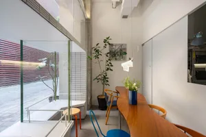 A modern living room featuring wooden furniture, glass windows, and metallic accents.