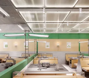 Industrial-style restaurant interior featuring steel countertops and modern fixtures.