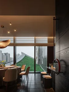 A modern restaurant interior with black lighting, metallic accents, and a rooftop view of the cityscape.