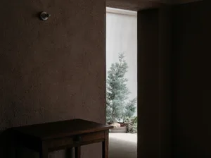 A minimalist interior with concrete walls and a wooden table.