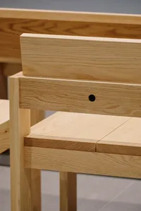 A modern minimalist wooden chair with a sleek, simple design.